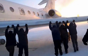 Passageiros empurram avião preso no gelo