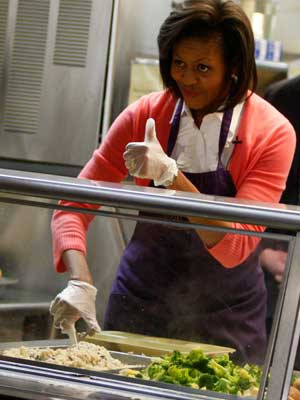 Michelle Obama distribui comida aos mais carenciados